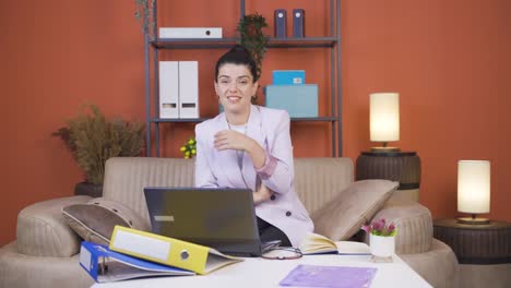 Home-office-worker-young-woman-looking-smugly-at-camera.